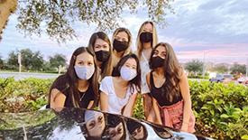 Six young women wearing masks