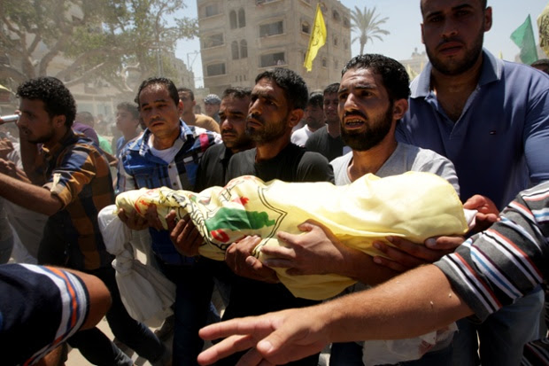 Relatives and friends of the al-Kaware family carry one of the bodies to the mosque during their funeral in Khan Yunis