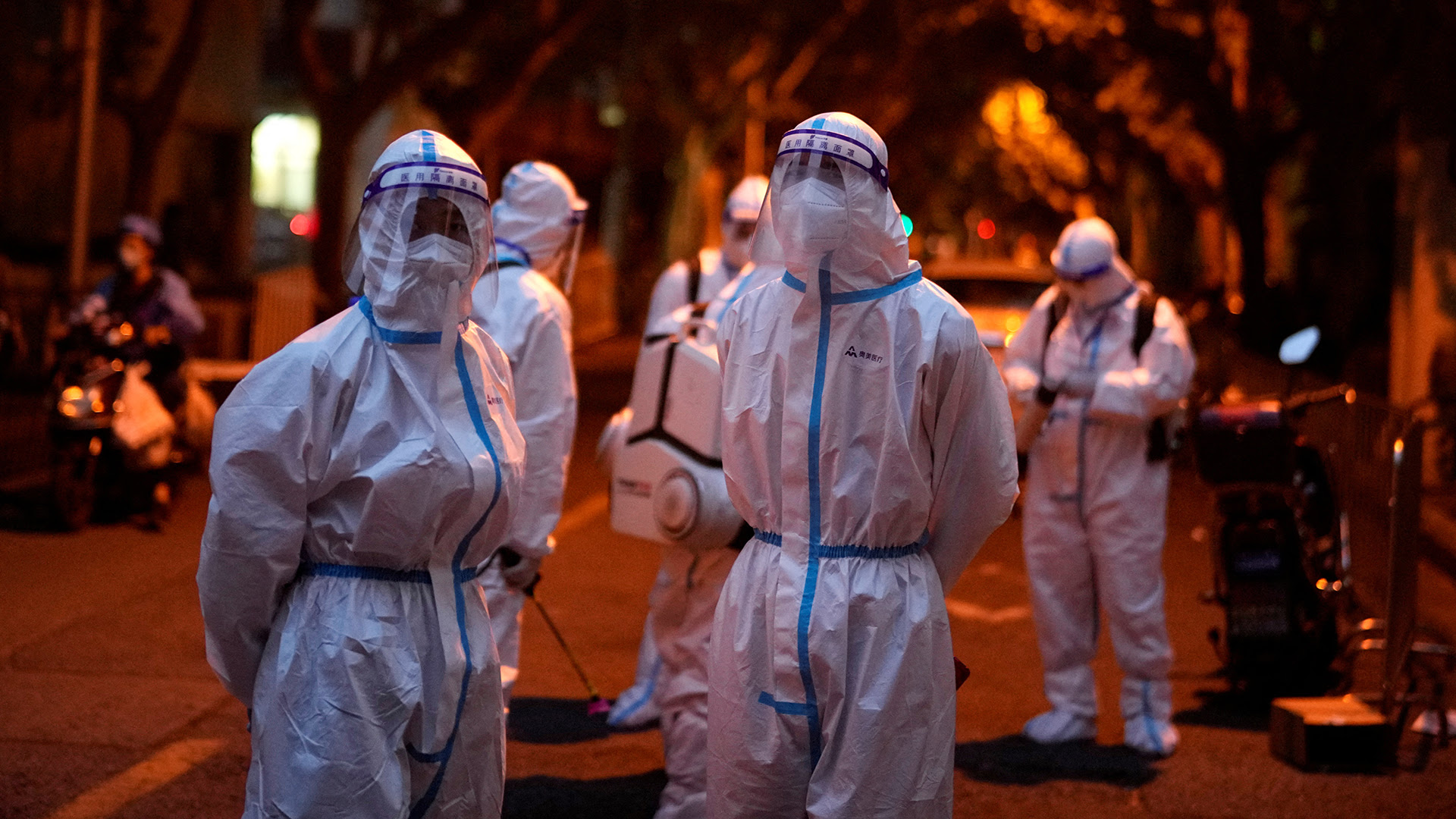 Workers in protective suits stand at a closed residential area during lockdown, amid the coronavirus disease (COVID-19) outbreak, in Shanghai, China, May 23, 2022 (Credit: Aly Song/Reuters)