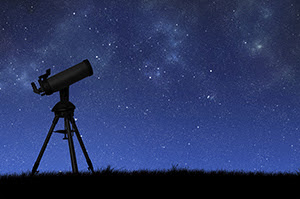 telescope in shadow against a star-filled sky