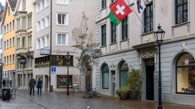 Rua de Zurique com comércios e bandeira da Suíça