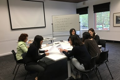 People seated around a table in an office.