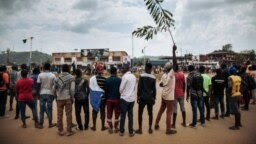 Les manifestants chantent l'hymne national congolais autour d'un rond-point à Beni lors d'une manifestation contre le report des élections sur le territoire des Beni et de la ville de Butembo le 27 décembre 2018.