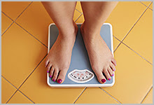 A young woman’s feet on a bathroom scale. 