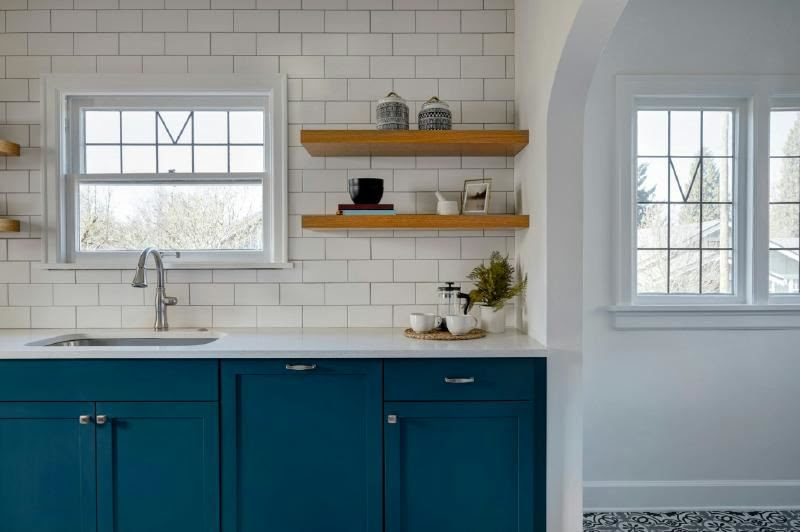 A kitchen with blue cabinets and shelves

Description automatically generated