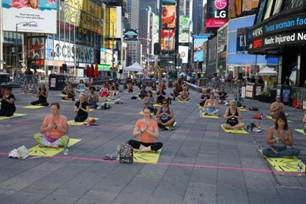 A group of people sitting on the ground in a plazaDescription automatically generated with low confidence