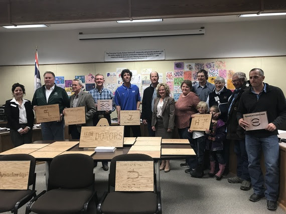 State Superintendent Jillian Balow stands with Converse County School District #1 board members and local donors while holding the signs recognizing their donations to the school district.