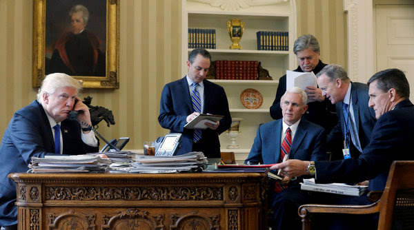 White House senior adviser Steve Bannon, standing at right, in the Oval Office while President Trump speaks with Russian President Vladimir Putin on Jan. 28. (Jonathan Ernst/Reuters)</p>