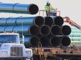 In this May 9, 2015, file photo, workers unload pipes in Worthing, S.D., for the Dakota Access oil pipeline that stretches from the Bakken oil fields in North Dakota to Illinois. A federal judge on Wednesday, March 25, 2020, ordered the U.S. Army Corps of Engineers to conduct a full environmental review of the Dakota Access pipeline, nearly three years after it began carrying oil. (AP Photo/Nati Harnik, File)