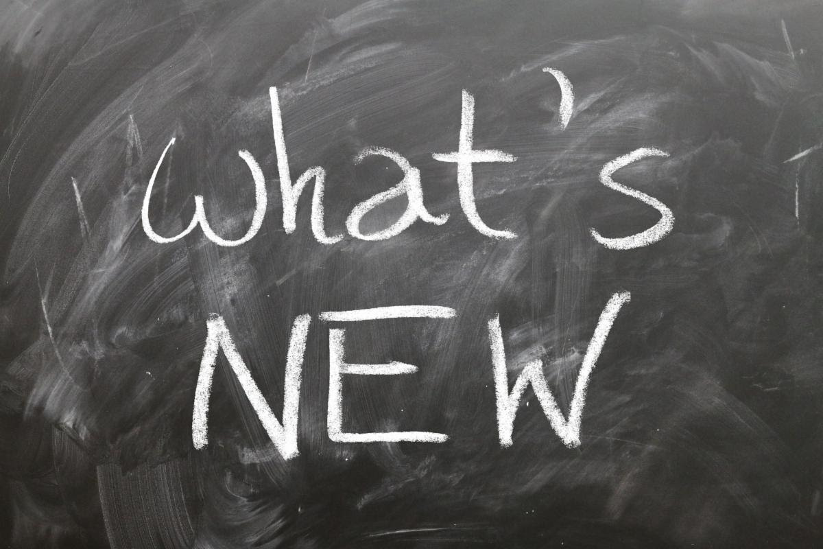 Chalkboard sign with the words "What's New" written across it with white chalk. 