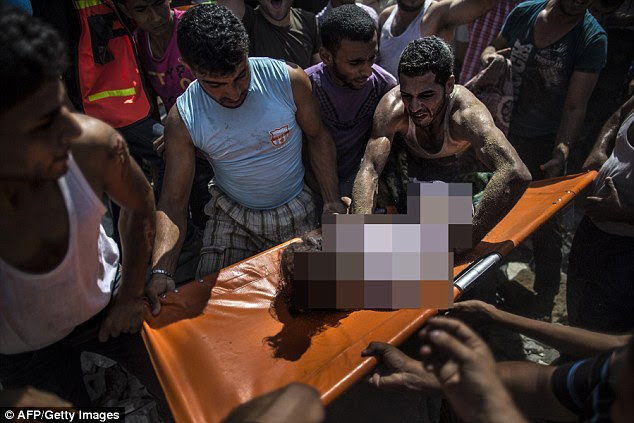 Palestinians remove the body of an eight-year-old from the rubble from a house hit by an Israeli airstrike in the al-Shati refugee camp in Gaza City today