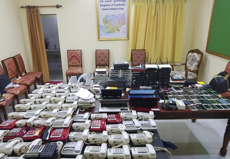 In this photo released by the Cambodia Immigration Police of the Interior Ministry and taken on Wednesday, Aug. 2, 2017, shows numerous telephones, mobile phones and computer networking equipment confiscated from fraud suspects at the immigration office in Poipet, western Cambodia, on the border with Thailand. (Cambodia Immigration Police of the Interior Ministry via AP)