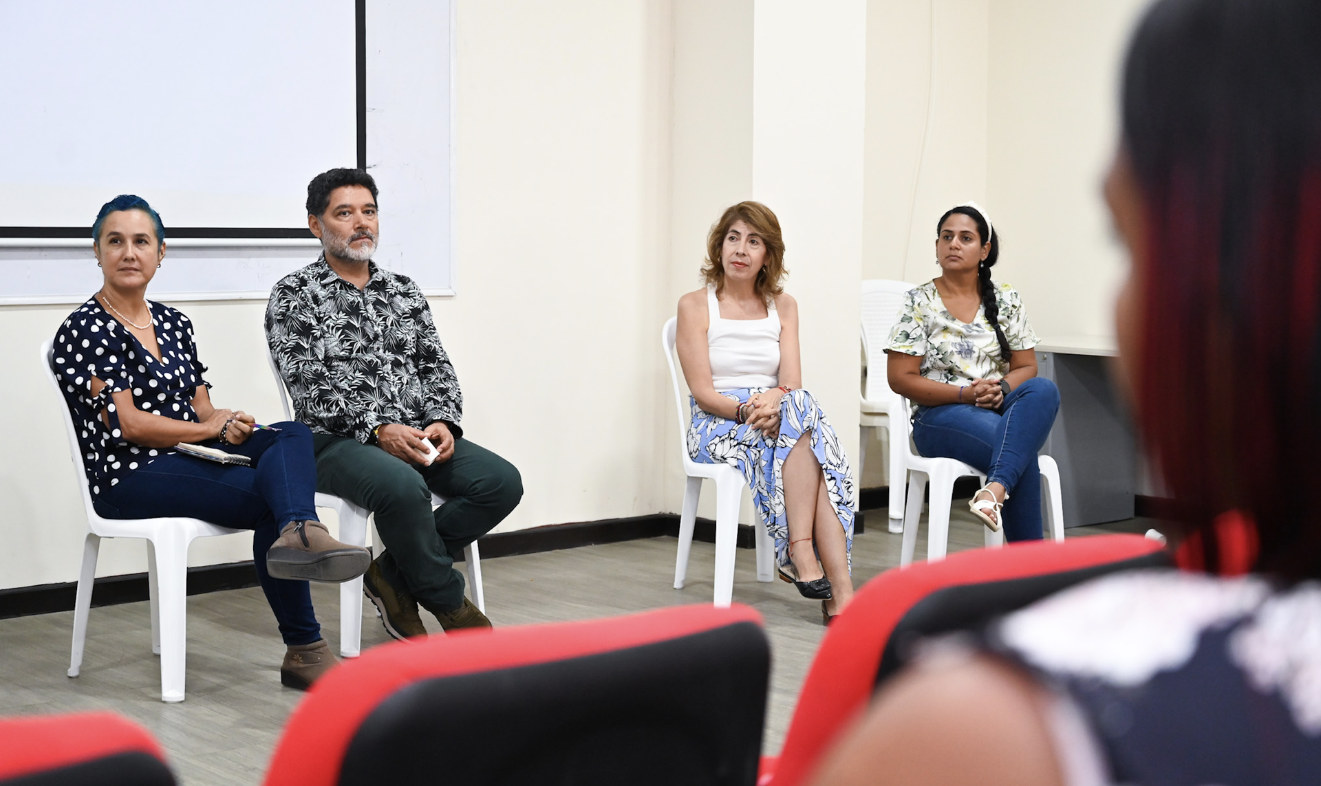 El rector de Uniguajira Carlos Robles, acompañado de una mujer, sentados, firmando un documento.