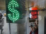 A man stands at an exchange office screen showing the currency exchange rates of U.S. Dollar and Euro to Russian Rubles in Moscow, Russia, Tuesday, March 10, 2020. Oil prices are plunging after Saudi Arabia started a price war against Russia. The Saudis tried to get the Russians to cut oil production to keep prices from falling even more due to the coronavirus. (AP Photo/Pavel Golovkin)