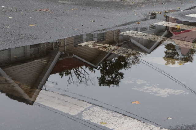 Houses in Queens in an area prone to flooding are reflected in a puddle during a Nor'easter in New York, U.S., October 26, 2021
