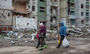 Un grupo de personas pasa junto a un edificio dañado por las bombas en Chernihiv, en el norte de Ucrania.