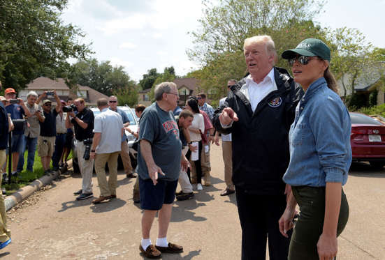 Slide 2 of 12: President Donald Trump and first lady Melania Trump stop to talk with residents impacted by Hurricane Harvey in a Houston neighborhood, Saturday, Sept. 2, 2017. (AP Photo/Susan Walsh)