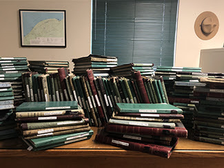Logbooks from the cabins and yurts at Porcupine Mountains Wilderness State Park are shown stacked.