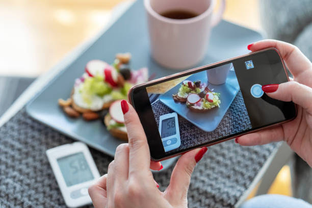 Young diabetic woman photographing her breakfast at home Young diabetic woman photographing her breakfast at home. control blood sugar levels stock pictures, royalty-free photos & images