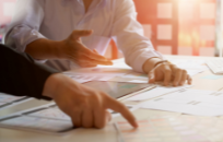 Researchers pointing at desk papers