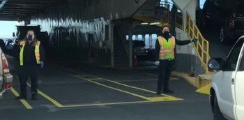 Photo of deck employees directing traffic loading onto a ferry