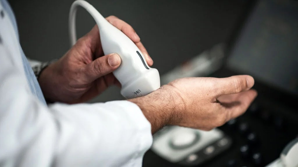 doctor holding ultrasound device over inner wrist