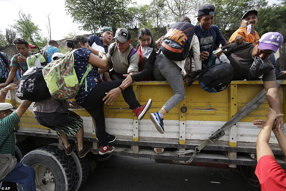 Honduran migrants bound to the U.S border climb into the bed of