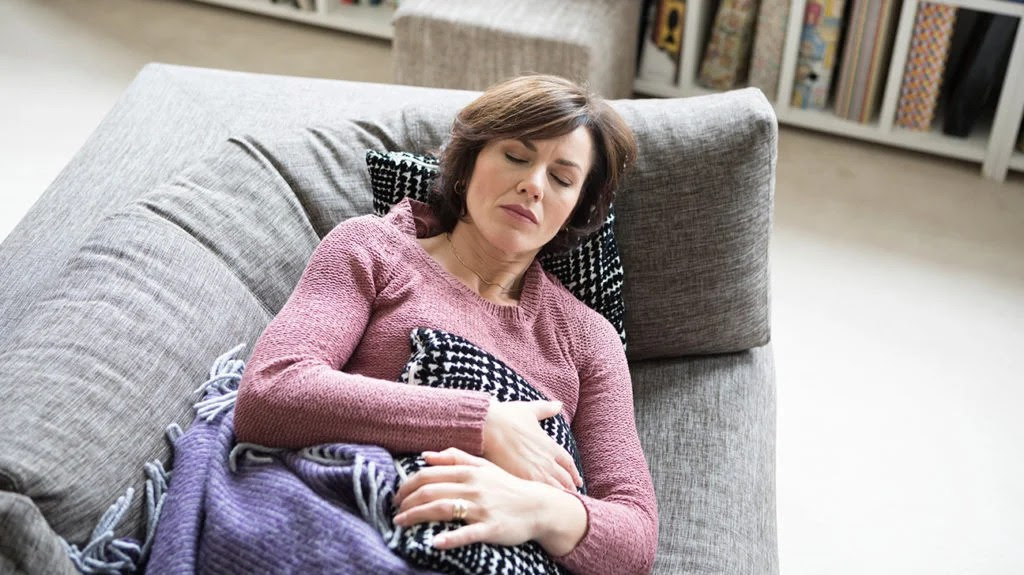 a woman holding her stomach because it sore from inflammatory bowel disease