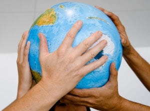 Photo of diverse hands holding a globe