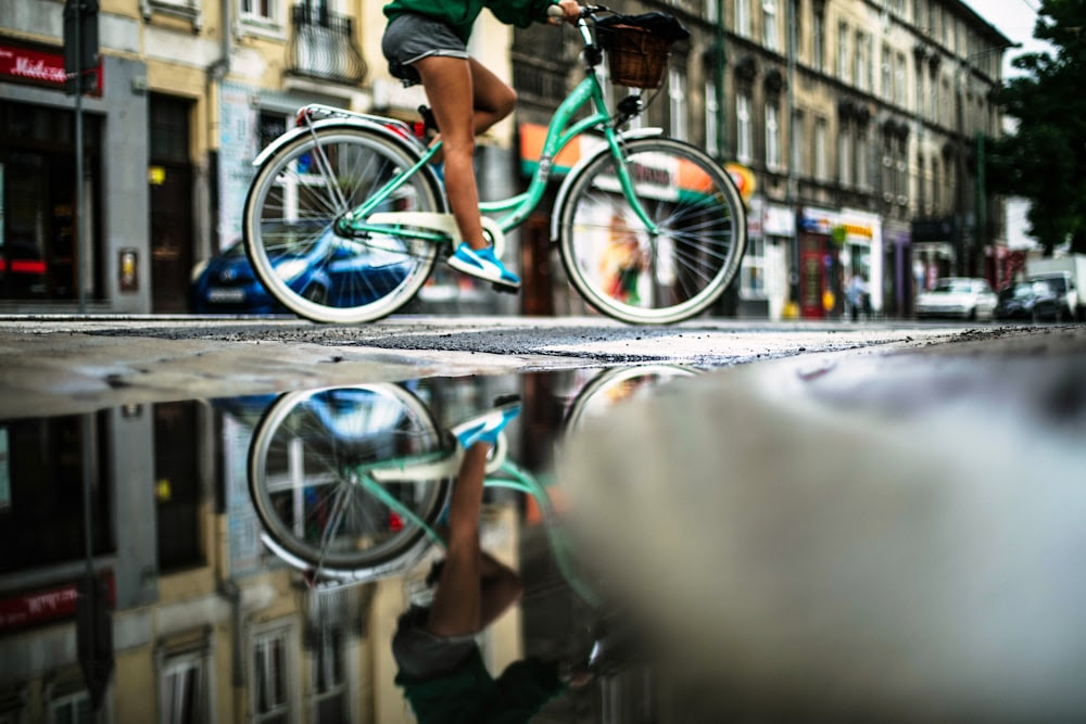 persona che guida su una bicicletta olandese verde acqua