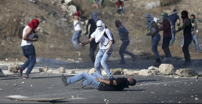 Un manifestante palestino herido yace en el suelo tras recibir un disparo de las tropas israelíes durante los enfrentamientos en el Hawara, puesto de control israelí cerca de la ciudad cisjordana de Naplusa.- REUTERS/Ahmad Talat