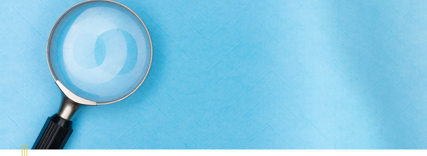 Image: Magnifying glass on a blue textured background.