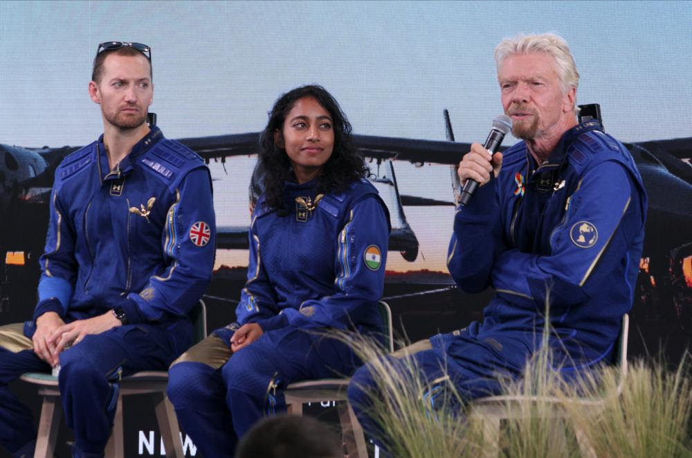 Richard Branson, right, answers questions while crewmates Sirisha Bandla and Colin Bennett listen during a news conference at Spaceport America near Truth or Consequences, N.M., on Sunday, July 11, 2021. Branson and the crew from his Virgin Galactic space tourism company reached an altitude of about 53 miles (88 kilometers) over the New Mexico desert before safely gliding back home to a runway landing at Spaceport America. (AP Photo/Susan Montoya Bryan)