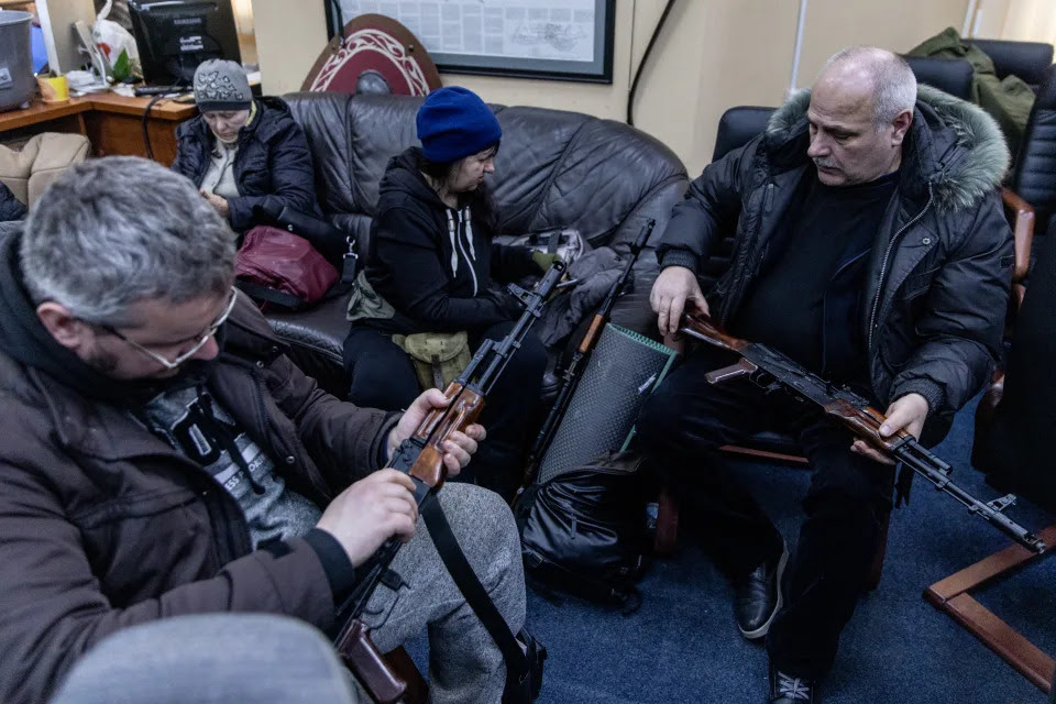 Civilian volunteers in Kyiv check their guns.