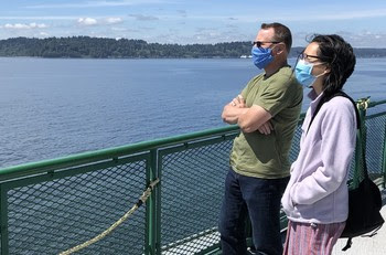 Photo of customers wearing masks on the outdoor deck of a ferry