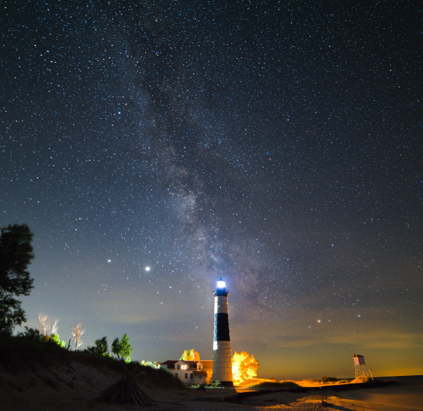 The Big Sable lighthouse glows beneath the starshine of the Milky Way Galaxy.