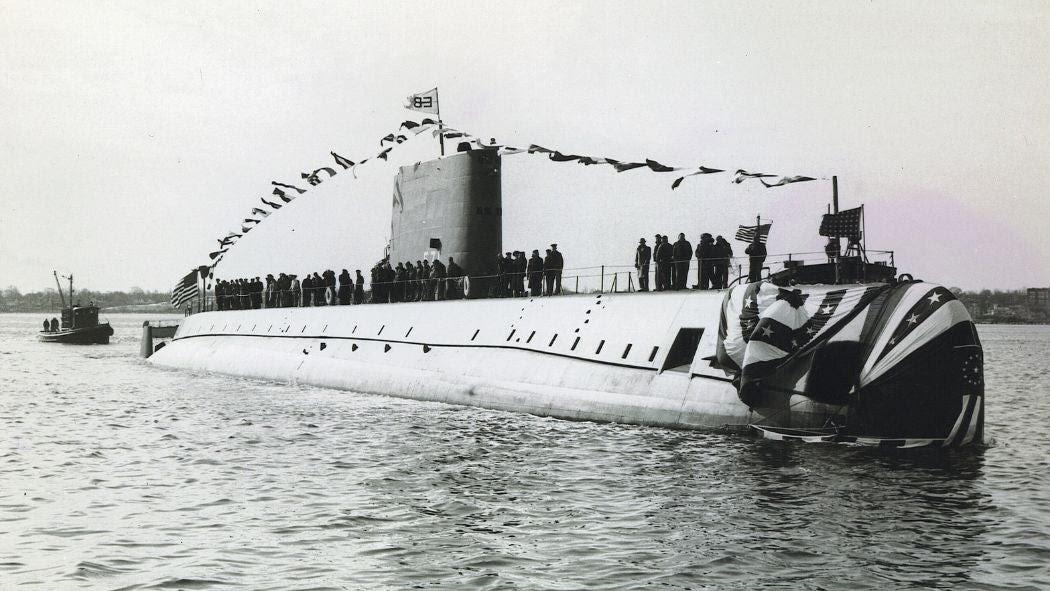 A black and white photo of the submarine adorned with flags at the inaugural launching of the historic new ship