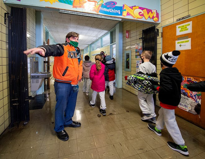 Principal Stephen DiCicco reminds students to social distance as they walk back to the classroom at St. Michael the Archangel School in Levittown on Friday.