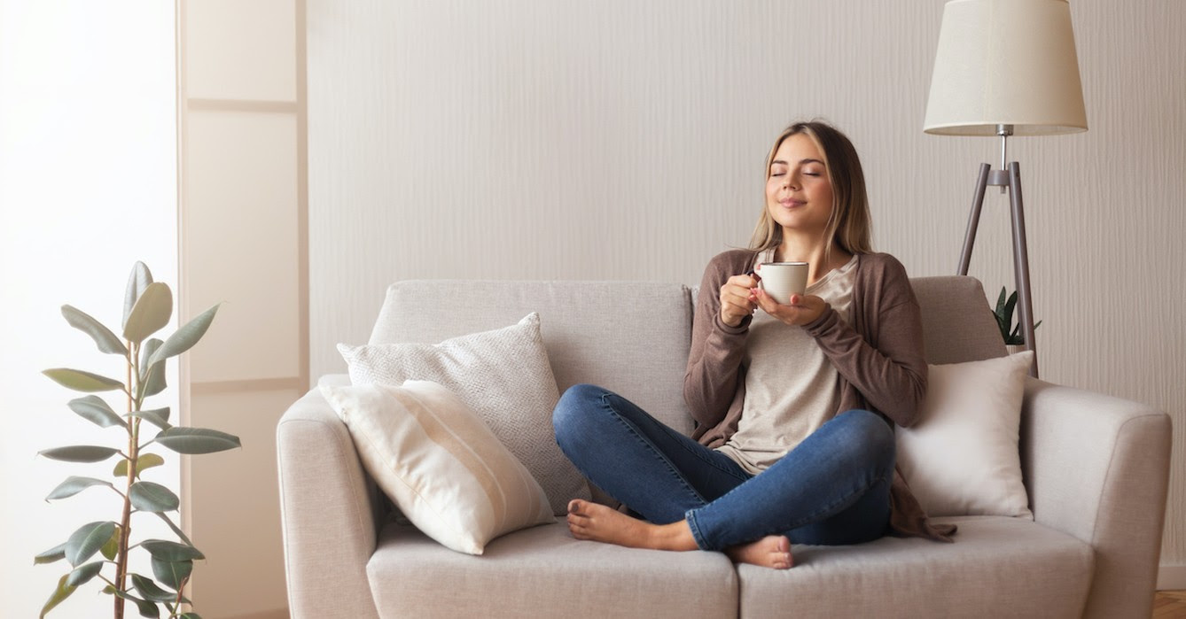woman peacefully resting on couch with coffee and eyes closed, prayers to rest in the Lord