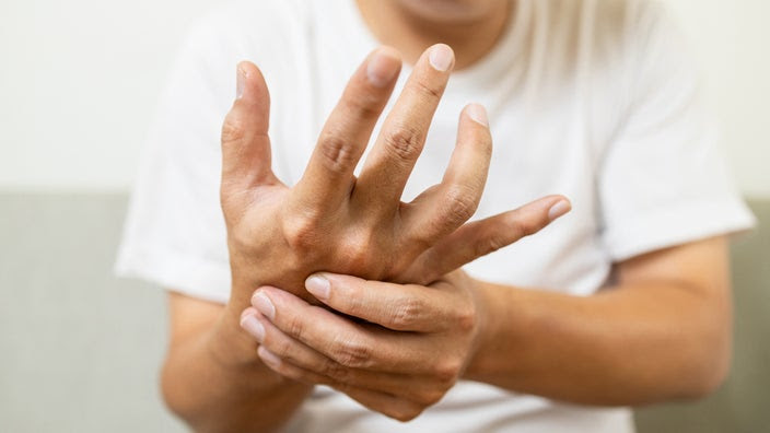 A close-up on the hands of a person with early-stage Parkinson's.