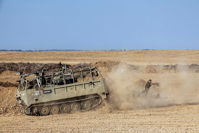 Israeli military vehicles and soldiers from an artillery unit gather near Israel's border with the Gaza Strip, in southern Israel, October 12, 2023. REUTERS/Ronen Zvulun