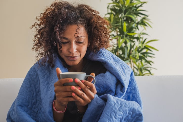 Sick woman drinks hot drink during cold weather