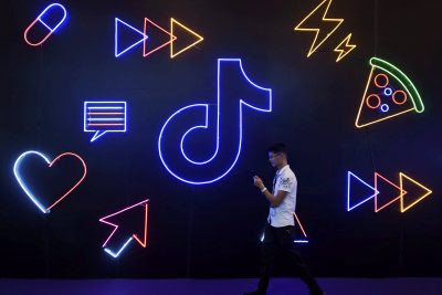 A man holding a phone walks past a sign of Chinese company ByteDance's
app TikTok, known locally as Douyin, at the International Artificial Products
Expo in Hangzhou, Zhejiang province, China, 18 October 2019 (Photo:
Reuters/Stringer).