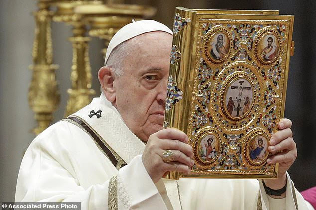 Pope Francis holds up the book of Gospels as he celebrates an Epiphany Mass in St. Peter's Basilica at the Vatican, Monday, Jan. 6, 2020. (AP Photo/Andrew Medichini)