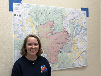 The DNR's Paige Gebhardt stands in front of a map she helped create on the Mullen Fire in Wyoming.
