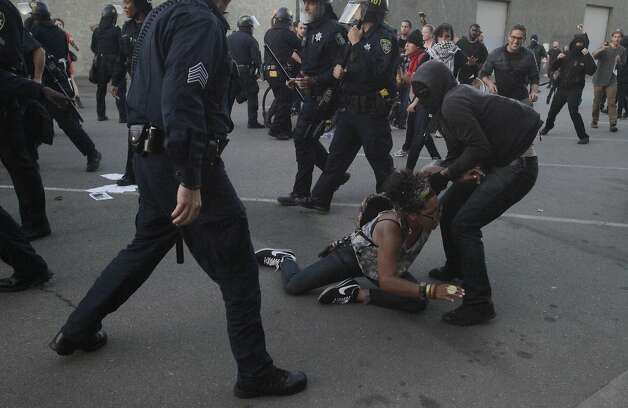 One protester helps a woman up after she was involved in a scuffle between police and a protester during an "F the Police" march held in solidarity with Ferguson, Mo., where there was a fatal shooting of an unarmed 18-year-old black man earlier in the week August 15, 2014 in Oakland, Calif. Photo: Leah Millis, The Chronicle