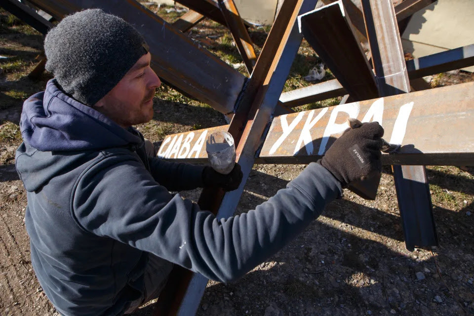 A man works on an anti-tank obstacle.