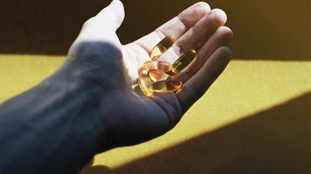 there is a close up of a person's hand holding various supplement pills