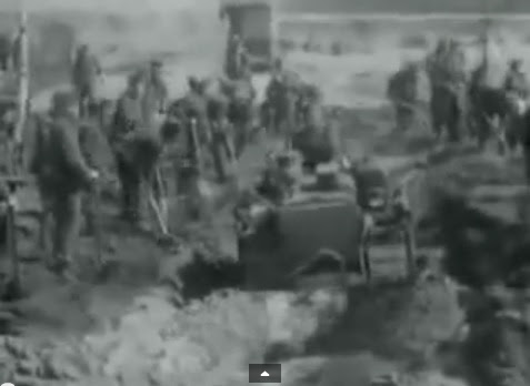 Region of Bergen-Belsen: SS has to                               dig out a mass grave and allies are                               helping with a bulldozer (6min. 48sec.)