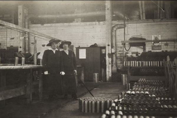 Black and white photo of two women in a munitions factory.
